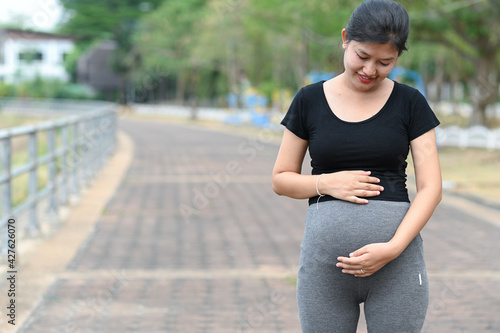 Pregnant woman holding baby booties. Belly with booties close up.