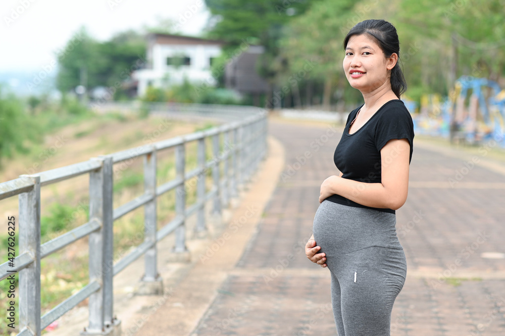 Fototapeta premium Pregnant woman holding baby booties. Belly with booties close up.