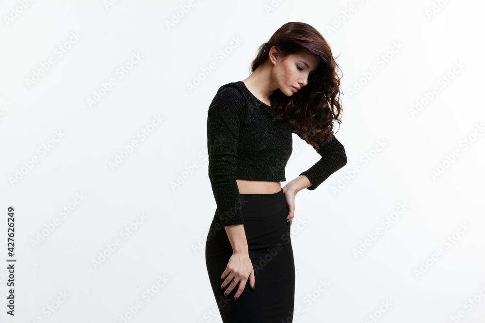 Beautiful young woman with brown long ringlets hairs and make up, wear black clothes, isolated on white background. Beautiful young woman with brown long ringlets hairs and make up, wear black clothes, isolated on white background.