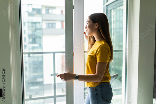 Young smile woman opening window in living room Free Download Young smile woman opening window in living room - GFXLoad