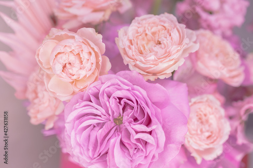 Light pink, purple, peach colour, white cute delicate small roses of different sizes, flowers in a lush bouquet. Close-up