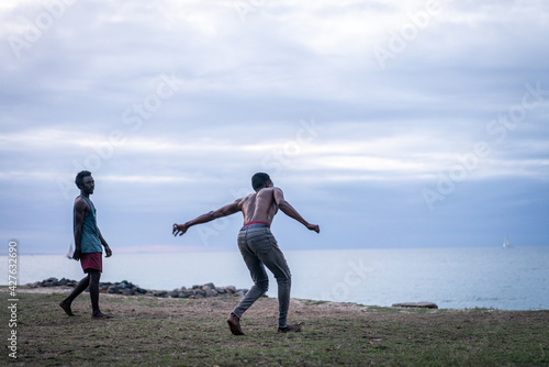 Young men exercising martial arts on the beach