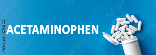 The word ACETAMINOPHEN is written near pills on a light blue background. Medical, health and happiness concept. drug, reduce fever and relieve pain, but which does not reduce inflammation