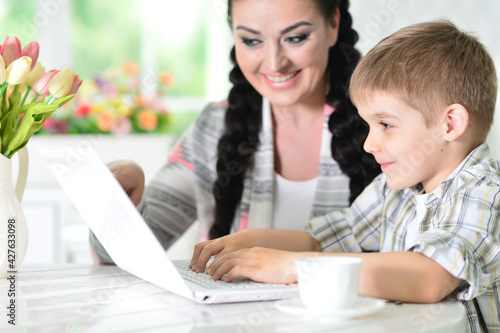 mother and son using modern laptop