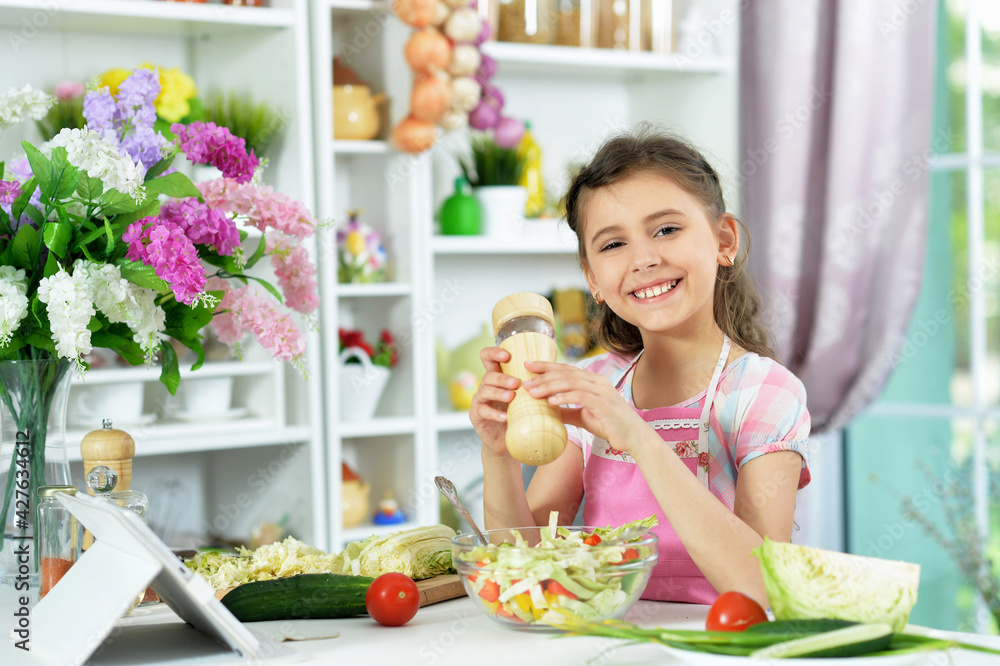 Cute little girl preparing fresh salad