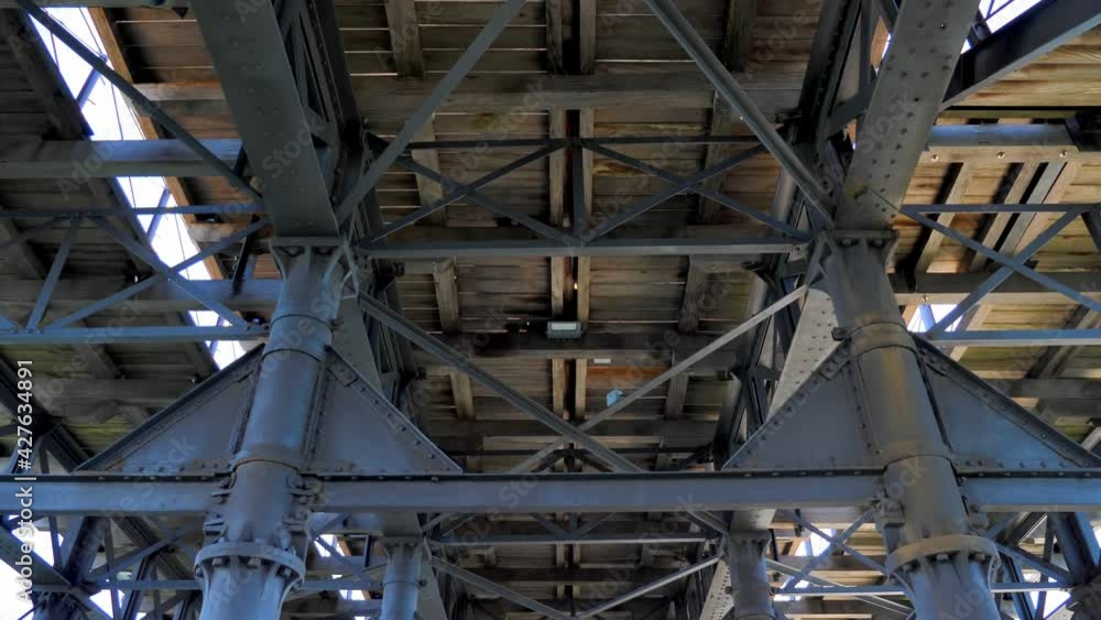 A view of the steel and wooden structure from the bottom. Metal trusses covered with old wooden planks. A view of the steel and wooden structure from the bottom. Metal trusses covered with old wooden planks.