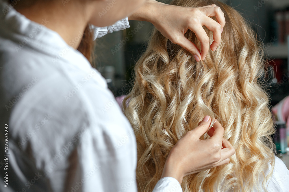 Naklejka premium Hair stylist finishing client's hair