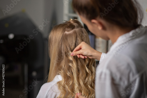 hair stylist hands touching client's curls