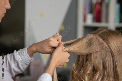 Hair stylist makes hairdo to a woman
