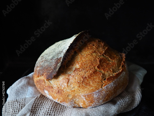 Homemade rustic sourdough bread on black background