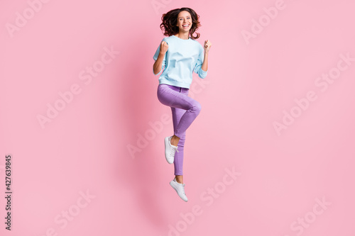 Full length body size photo of jumping brunette girl gesturing like winner isolated on pastel pink color background