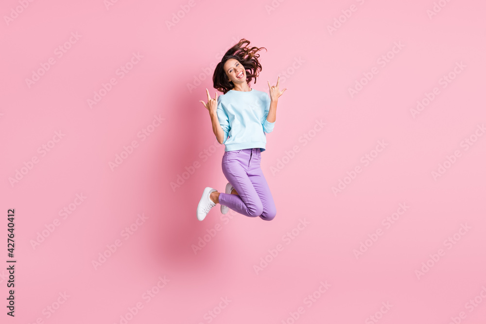 Full body photo of young attractive girl happy positive smile jump show rock sign isolated over pink color background