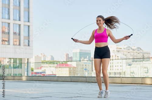 Jumping on a rope is a young athlete in the background of the city.