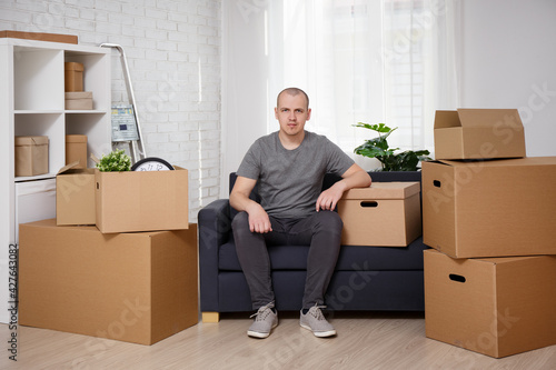 moving day concept - happy man sitting on sofa in room © Di Studio