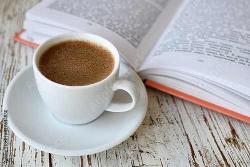Сup of coffee and a book on table