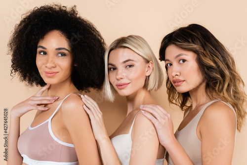 young interracial women in underwear posing on beige