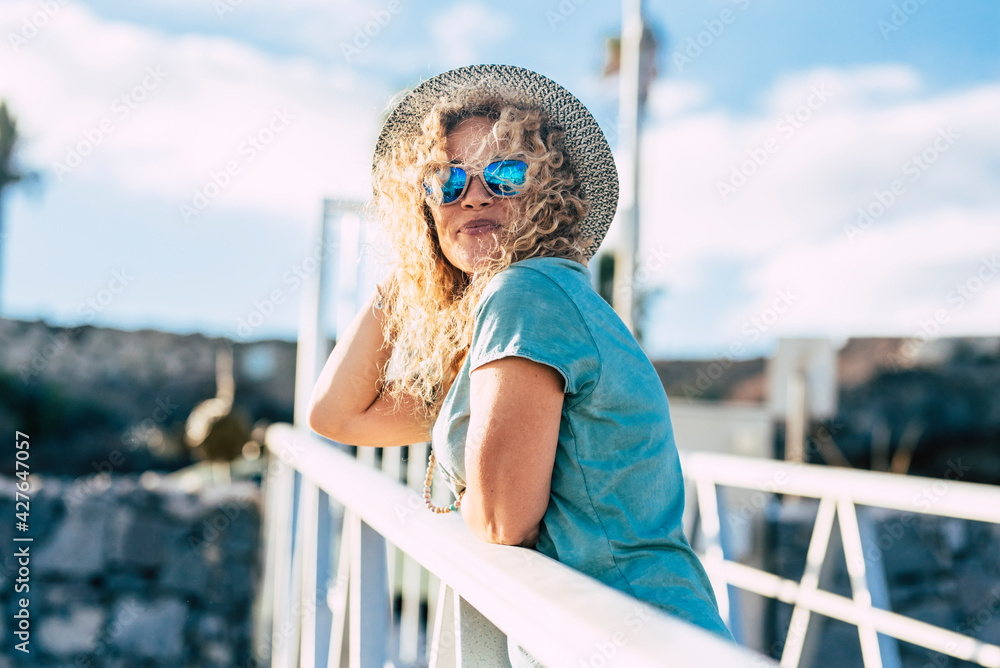 Pretty adult young woman smile and enjoy outdoor leisure activity in sunny day - middle age female people caucasian with trendy hat - nice joyful lifestyle concept