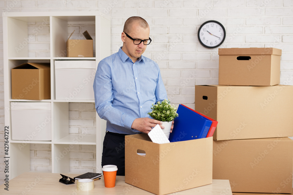 Happy businessman packing things in boxes Happy businessman packing things in boxes