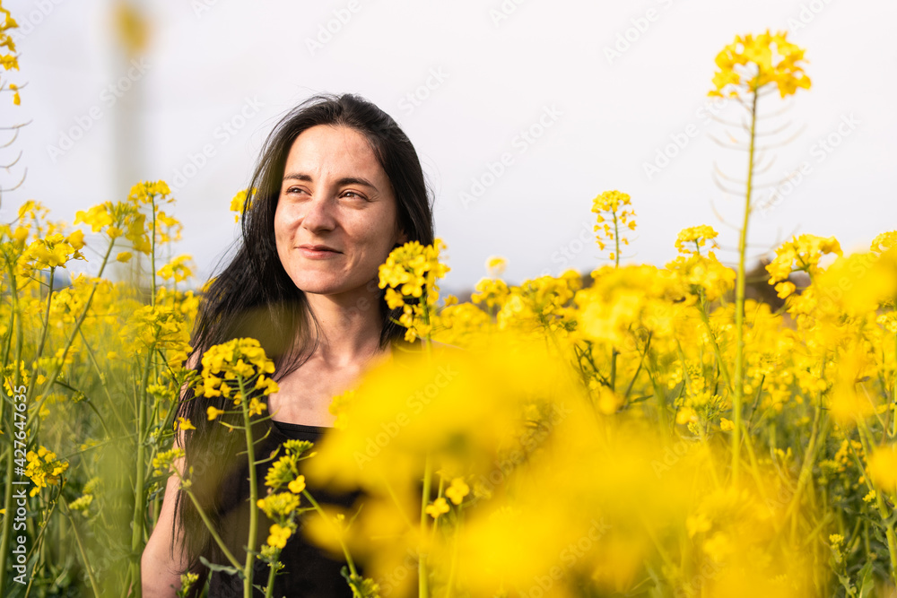 portrait of a girl in springtime in a field of yellow flowers portrait of a girl in springtime in a field of yellow flowers