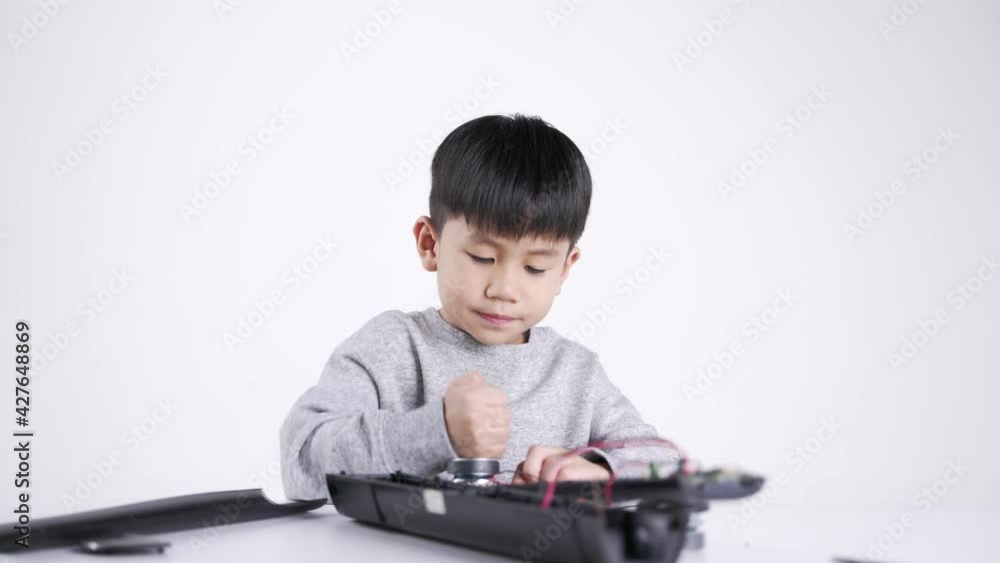 Asian boy about 5 years old connecting speaker wires for fixing the electronic device Asian boy about 5 years old connecting speaker wires for fixing the electronic device