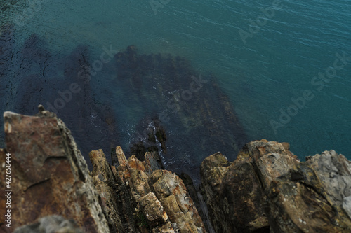 Gorgeous beautiful seascape from drone. View from a high cliff to the blue turquoise clear sea and coral reefs under the water.