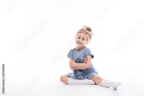 Portrait of beautiful little child model charming smile posing in the studio on a white