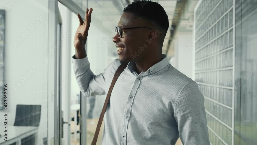 A happy american guy is walking down the hall inside the office building A happy american guy is walking down the hall inside the office building