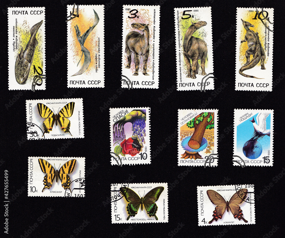 A set of postage stamps. Collage with fauna. Dinosaurs and Butterflies. Drawing on an old stamp. Wild animal on postage stamps. USSR - circa 1990.