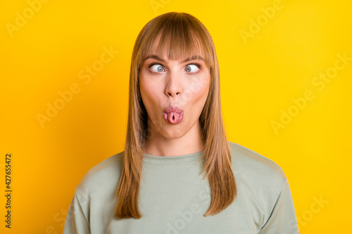 Close-up portrait of nice attractive foolish naughty girl grimacing teasing you isolated over bright yellow color background