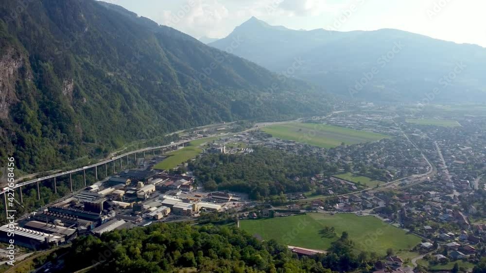 Aerial pan left from a polluted valley to a highway in the mountains. Vallée de l'Arve, French Alps. Aerial pan left from a polluted valley to a highway in the mountains. Vallée de l'Arve, French Alps.