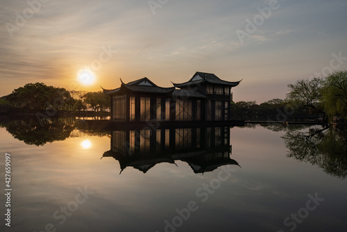 Morning landscapes with trees, cherry blossoms and pond in Quyuan Garden, a public park of West Lake in Hangzhou, China