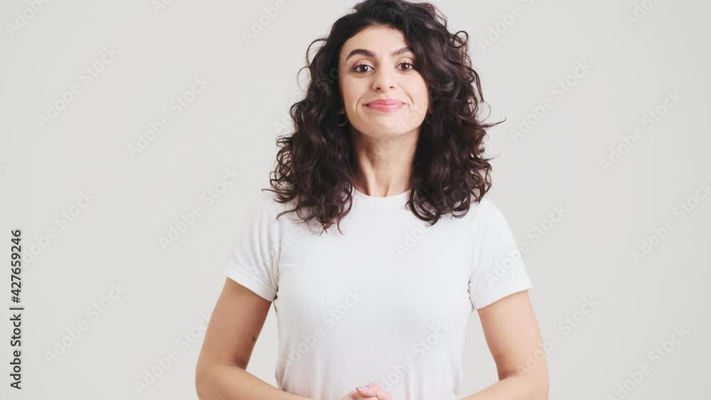 The smiling woman positively shaking her head at the camera while standing in the studio The smiling woman positively shaking her head at the camera while standing in the studio