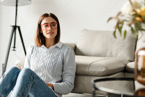 Free Download Smiling middle aged woman in sweater holding glasses - GFXLoad