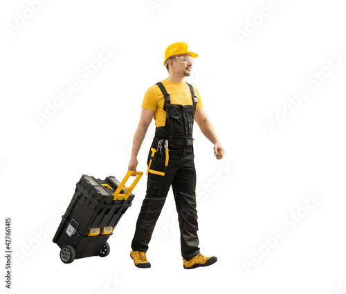 worker repairman or builder walked with construction tools in big tool-box on wheels