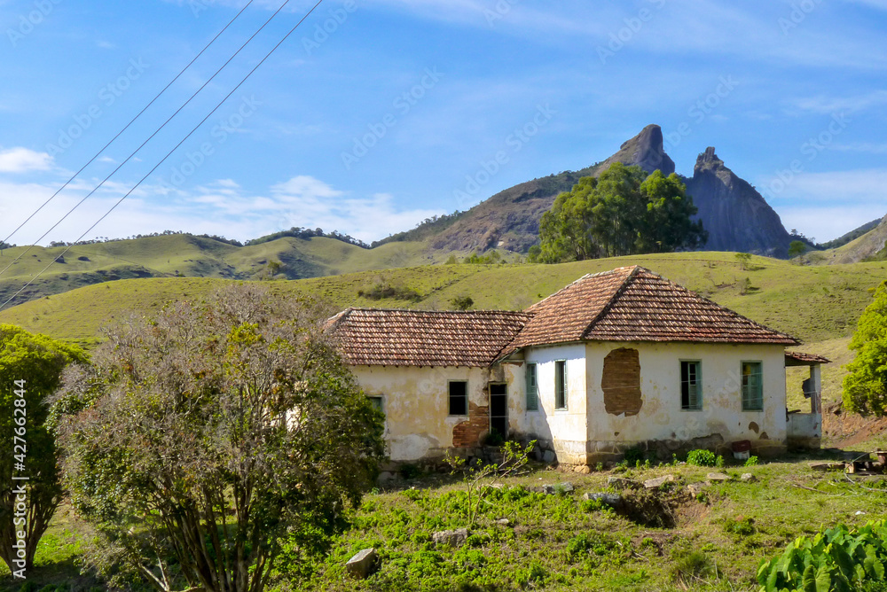 Old abandoned house overlooking the Dois Bicos hill in the background, Buraco do Ouro valley, Teresopolis city, Rio de Janeiro state, Brazil Old abandoned house overlooking the Dois Bicos hill in the background, Buraco do Ouro valley, Teresopolis city, Rio de Janeiro state, Brazil
