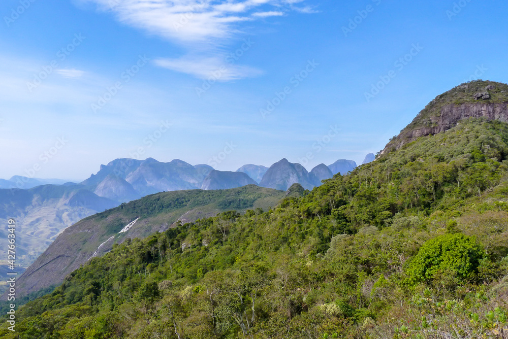 Trail and stone of Buraco do Ouro, with the mountains of Vale dos Frades in the background, Teresopolis, State of Rio de Janeiro, Brazil