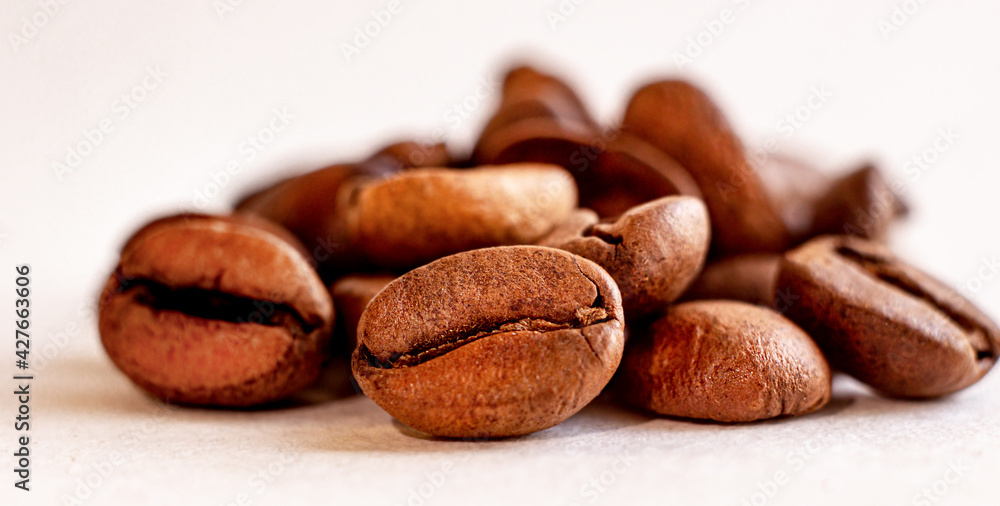 Roasted coffee beans, on a white background. Selective focus. Macro Roasted coffee beans, on a white background. Selective focus. Macro