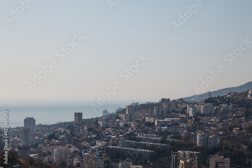panorama of a small town at dawn, mountains, sea and haze with fog