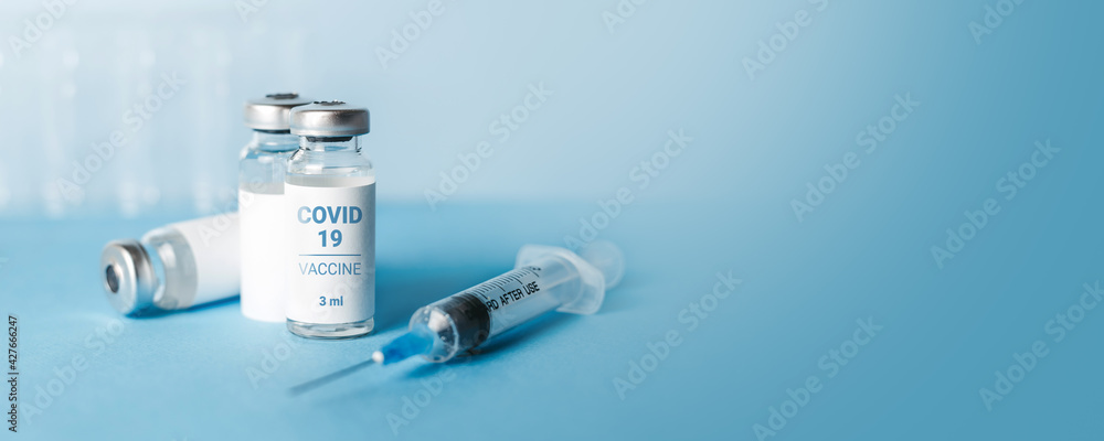 Coronavirus vaccine banner. Ampoules with coronavirus vaccine and a syringe on blue background. Covid-19 treatment Coronavirus vaccine banner. Ampoules with coronavirus vaccine and a syringe on blue background. Covid-19 treatment