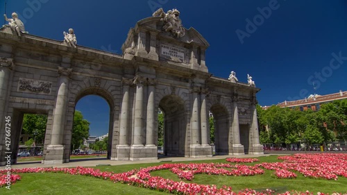 The Puerta de Alcala timelapse hyperlapse (Alcala Gate) with flowers and traffic is a Neo-classical monument in the Plaza de la Independencia (Independence Square) in Madrid, Spain.