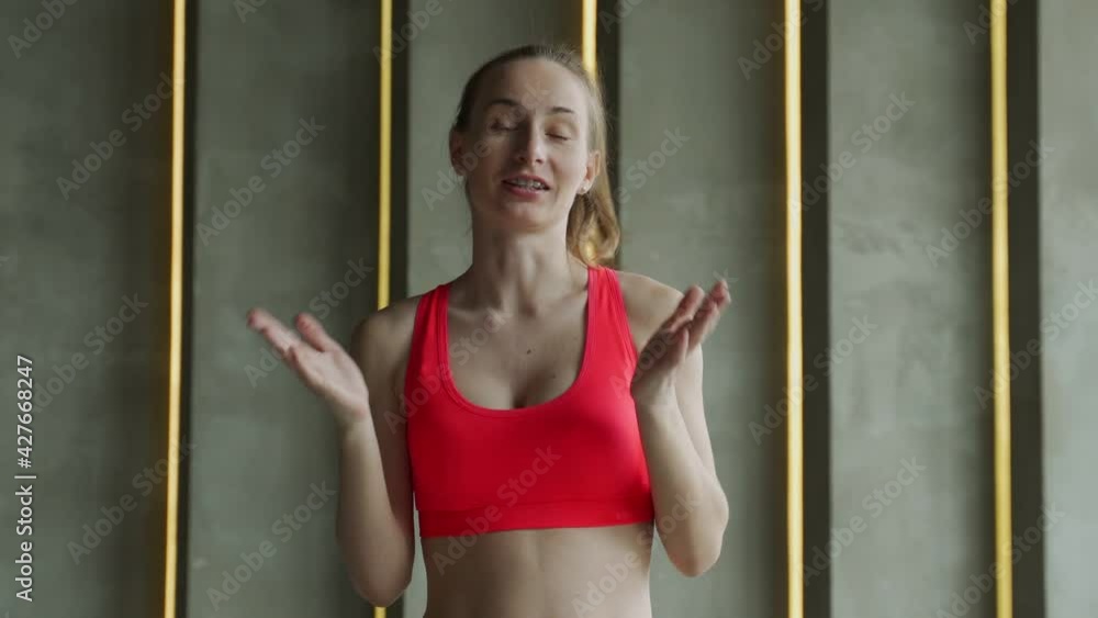 Woman athlete stands and looks at the camera and talks about the purpose of the training.