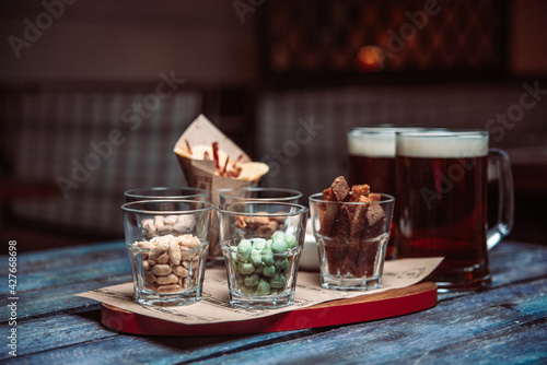 snacks to beer in glass glasses on a wooden table