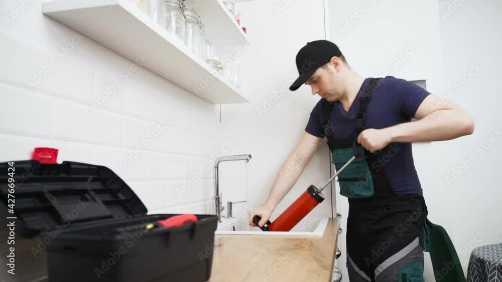 Plumber unclogging kitchen sink with professional force pump cleaner. Plumber unclogging kitchen sink with professional force pump cleaner.