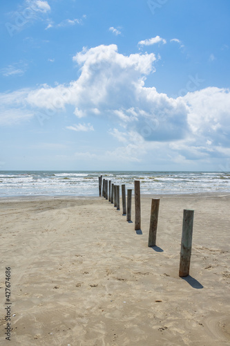 Poles in the beach with ocean and blue sky background 