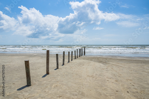 Poles in the beach with ocean and blue sky background 