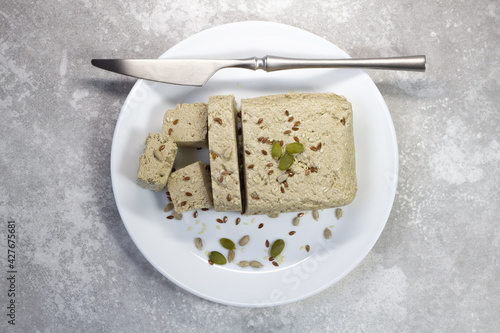 Halva close up on a white plate on a gray background. Traditional oriental dessert sweet halva. Halva made from sunflower seeds. top view, flat lay, copy space.