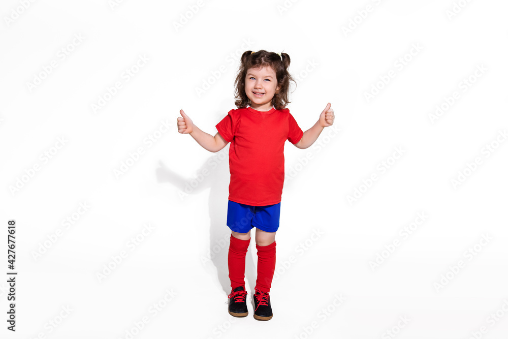 small beautiful girl 5 years in football uniform isolated on white background looking at camera. Women's football concept for kids. Photo for advertising football club for children small beautiful girl 5 years in football uniform isolated on white background looking at camera. Women's football concept for kids. Photo for advertising football club for children