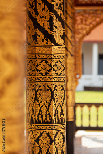 Small temple or chapel, with plant motifs drawn on its columns next to Phra tamnak Daeng, in Bangkok National Museum, example of Thai architecture. photo