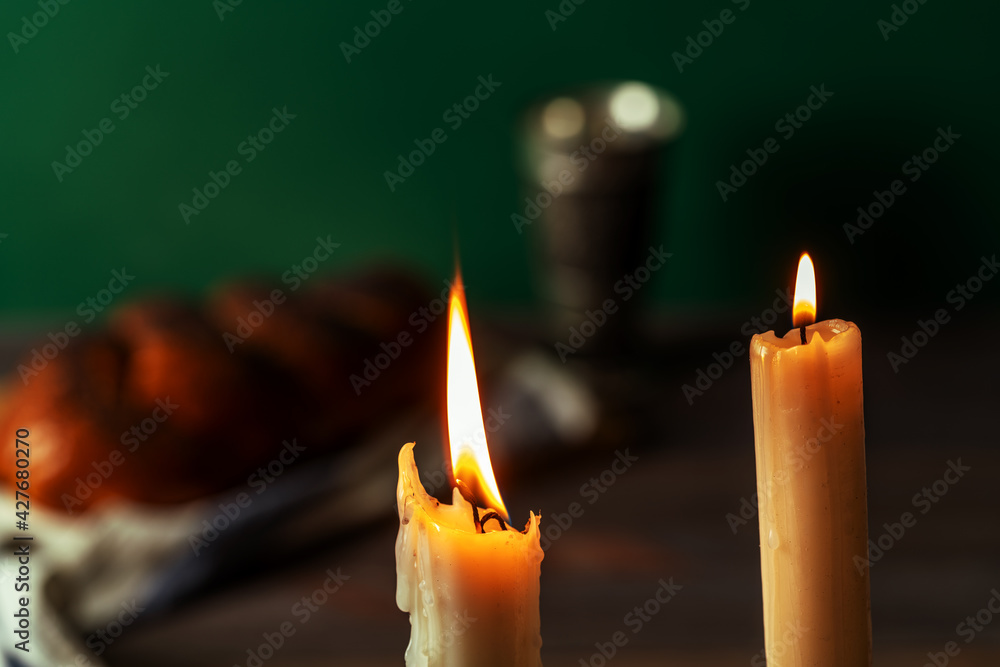 Shabbat Shalom. Challah bread, shabbat wine and candles on wooden table.