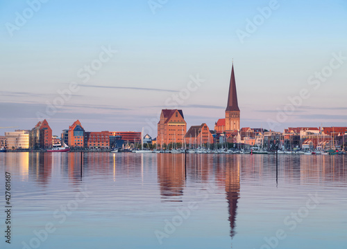 Rostock, Germany. City skyline reflecting in water of Warnow river in the evening